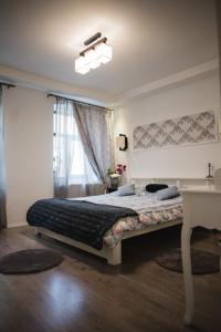 um quarto com uma cama, uma secretária e uma janela em Casa Randunicii - Swallow House em Sibiu