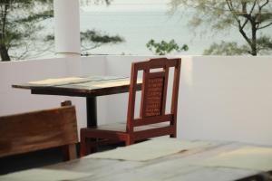 una sedia in legno seduta di fronte a un tavolo di Petit Elephant a Cherai Beach