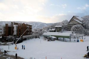 een groep mensen op een skipiste in de sneeuw bij Les Chalets 20 in Falls Creek