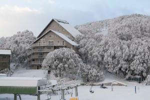een skihut in de sneeuw naast een berg bij Les Chalets 20 in Falls Creek