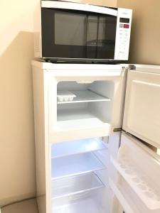 a microwave oven sitting on top of a refrigerator at ROSE ROOM in Fukuyama