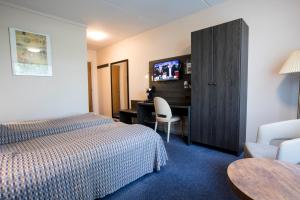 a hotel room with a bed and a desk at Hotel Falster in Nykøbing Falster +16 photos