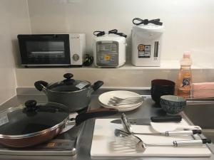 a kitchen counter with a stove with utensils on it at Weekly Harbourview Mansion Ginowan in Ginowan
