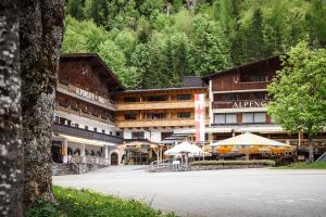 a hotel in the mountains with a parking lot at Das Naturhotel die Eng in Hinterriss