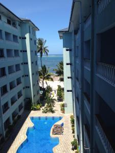 een uitzicht vanaf het balkon van het hotel en het strand bij Cowrie Luxury Beach Studio in Mombasa