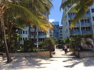 a palm tree in front of a building at Cowrie Luxury Beach Studio in Mombasa