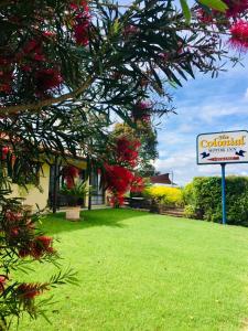 una señal frente a una casa con un patio en Colonial Motor Inn Pambula, en Pambula