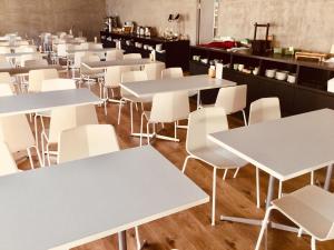 a room filled with tables and white chairs at Ariston Hotel Miyazaki in Miyazaki