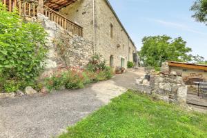 a stone building with a pathway next to a yard at Le Mas des Papillons in Fargues