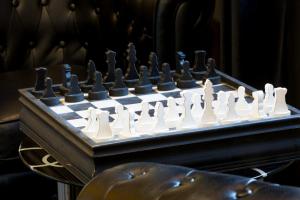 a chess board with white and black chess at Hotel Best Western La Mare Ô Poissons in Ouistreham