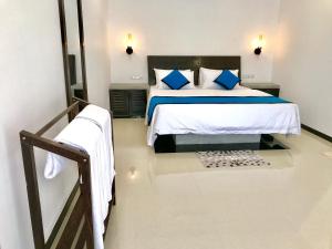 ein Schlafzimmer mit einem Bett mit blauen und weißen Kissen in der Unterkunft CK House Unawatuna in Unawatuna + 38 Fotos