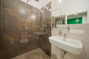 a bathroom with a sink and a mirror at City Vibes Apartments in Krakow
