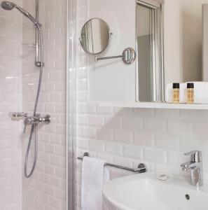 Un baño con ducha, lavabo y espejo. en Hôtel des Ecrivains, en París 16 fotos más