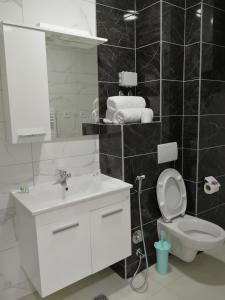 a white bathroom with a sink and a toilet at VIP Apartments in Sarajevo