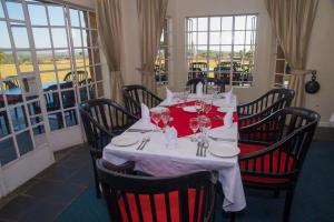uma sala de jantar com uma mesa com copos de vinho em Game Haven Lodge em Blantyre