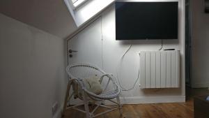 a room with a chair and a flat screen tv at Le Rooftop des Halles in Biarritz