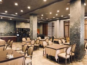 バクーにあるGM City Hotelのテーブルと椅子のあるレストラン、キッチンが備わります。