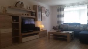 a living room with a blue couch and a tv at Ferienwohnung "Steffi", Bostalsee in Nohfelden