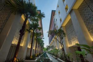 a street with palm trees between two buildings at Bali Paragon Resort Hotel in Jimbaran