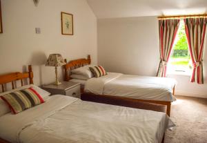 a bedroom with two beds and a window at The Waterside Cottages in Nenagh