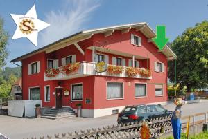 a red building with a dollar sign on it at Wirtshaus zum Stern in Satteins