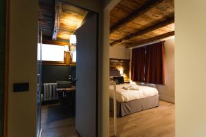 a bedroom with a bed in a room with wooden ceilings at Granuit room & breakfast in Sauze di Cesana +20 photos