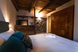 a bedroom with a white bed with a wooden door at Granuit room & breakfast in Sauze di Cesana