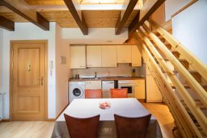 a kitchen with a table and chairs in a room at Inmocyma Prau Llargo in El Run