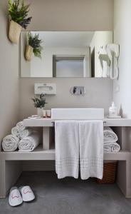 a bathroom with a sink with towels and a mirror at VOI Marsa Siclà Essentia in Sampieri