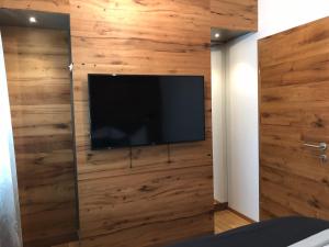 Elle comprend une télévision à écran plat fixée sur un mur en bois. dans l'établissement Am Holzmeisterweg 31 "Erika", à Gosau