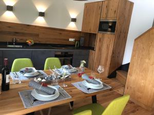 a wooden dining room table with green chairs around it at Am Holzmeisterweg 31 "Erika" in Gosau