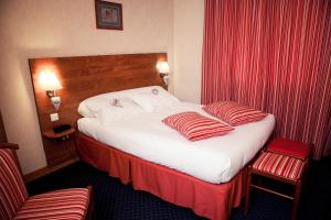 a hotel room with a large bed with red curtains at Au Feu de Bois in Amou