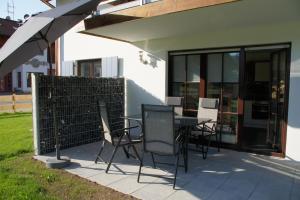 eine Terrasse mit einem Tisch und Stühlen neben einem Gebäude in der Unterkunft Ferienwohnungen Ellen Müller in Fischen im Allgäu