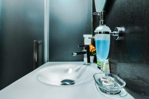 ein Waschbecken mit einem Wasserhahn und einem Glas in der Unterkunft Champs-Élysées Sofia | 2-BDR, 2-BTHR Tsar Simeon Suite in Sofia