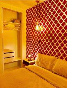 1 dormitorio con cama y pared roja en 48 BENIDORM, en Benidorm