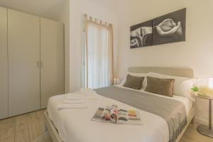 a bedroom with a bed with two magazines on it at The Sweet Square Flat in Varenna