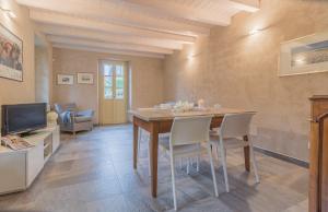 a dining room with a table and chairs and a tv at Del Duca Apartment in Varenna