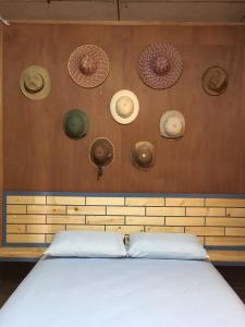 a wall with hats on it with a bed at ซอยห้า โฮมสเตย์ เชียงคาน in Chiang Khan