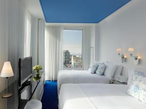a hotel room with two beds and a window at NoMo SoHo in New York