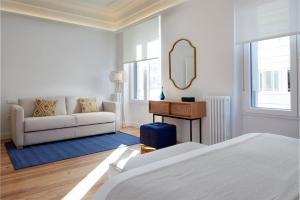 ein weißes Zimmer mit einem Bett und einem Sofa in der Unterkunft Mayflower by FeelFree Rentals in San Sebastián
