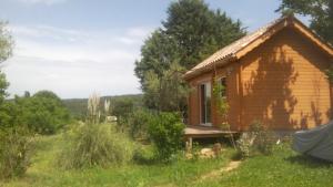 una pequeña casa de madera en un campo con árboles en Les Hauts du Clos 645 le Rayol, en Correns
