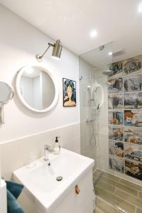 een witte badkamer met een wastafel en een douche bij R56 Apartment in Boedapest