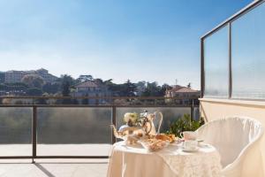 une table avec une assiette de nourriture sur un balcon dans l'établissement Hotel Cacciani, à Frascati