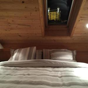 Bett in einem Holzzimmer mit Fenster in der Unterkunft The Chalet in Gstaad