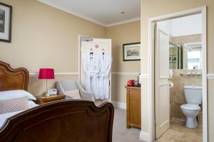 a bedroom with a bed and a shower and a toilet at Crossways Guest House in Cheltenham