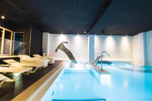 una grande piscina con sedie e tavolo di Sentido Fido Punta del Mar Hotel & Spa - Adults Only a Santa Ponsa
