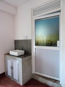 a bathroom with a sink and a window at Beach Break Surf Hostel in Weligama