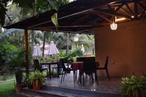 une terrasse avec une table, des chaises et des parasols dans l'établissement Elegant Shades, à Colva