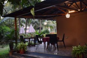 a patio with a table and chairs and umbrellas at Elegant Shades in Colva