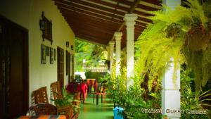 Vihangi Guesthouse في دامبولا: شرفة مع طاولة وكراسي ومبنى